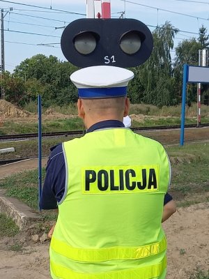 policjanci oraz pracownicy kolei na  przejeździe klejowym.