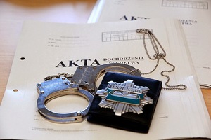 Policyjne akta, kajdanki oraz odznaka Policyjna.