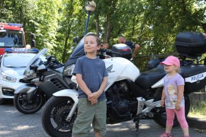 chłopiec i dziewczynka stoją na tle policyjnych motocykli