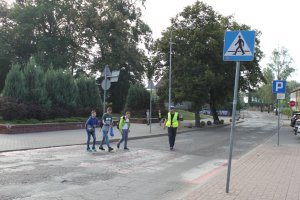 policjanci zabezpieczają przejście dla pieszych po którym idą chłopcy do szkoły