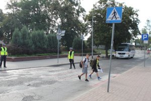 policjanci zabezpieczają przejście dla pieszych po którym idą chłopcy do szkoły