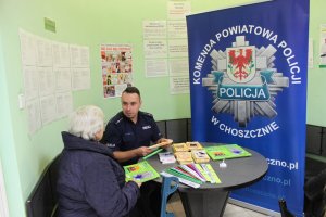 Policjant rozmawia z seniorką w inspektoracie ZUS w Choszcznie