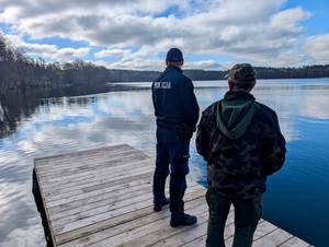 Funkcjonariusz Policji wspólnie z funkcjonariuszem Straży Rybackiej na pomoście
