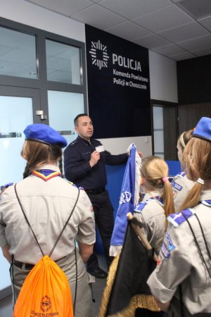 Policjant oprowadza grupę harcerzy po budynku Komendy Powiatowej Policji w Choszcznie