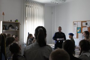 Policjant oprowadza grupę harcerzy po budynku Komendy Powiatowej Policji w Choszcznie