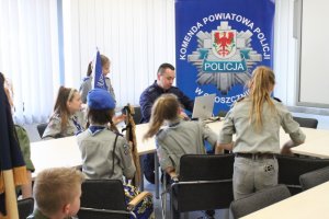 Policjant oprowadza grupę harcerzy po budynku Komendy Powiatowej Policji w Choszcznie