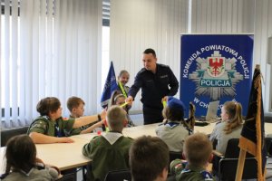 Policjant oprowadza grupę harcerzy po budynku Komendy Powiatowej Policji w Choszcznie