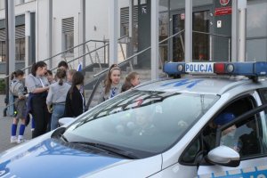 harcerze wsiadają do policyjnego radiowozu